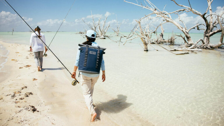 Two people walking on the sandbar on their way to inshore fly fish in Punta Allen, Mexico