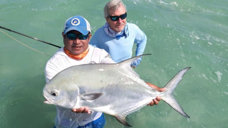 Two fly fishermen catch a permit in Ascension Bay, Mexico.