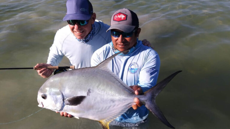 An inshore fly fishermen catches a permit in Ascension Bay, Mexico.