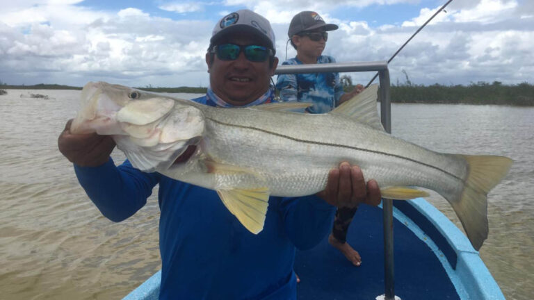 Two fly fishermen catch a tarpon in Ascension Bay, Mexico.