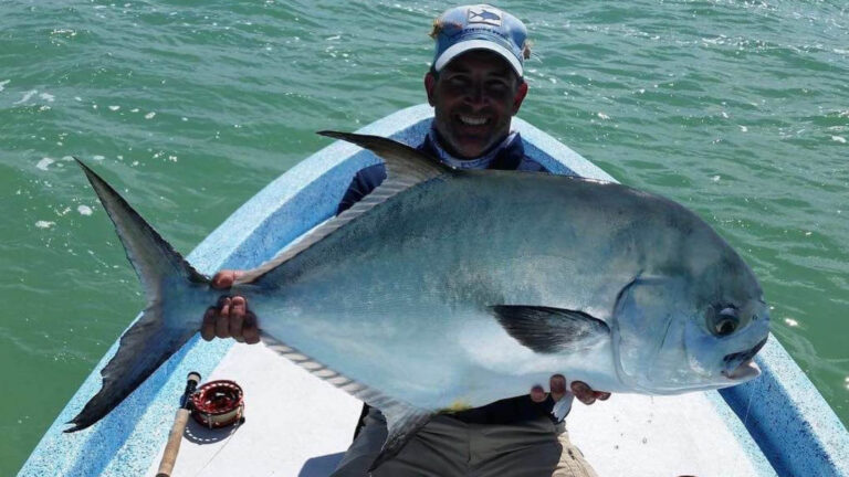 A fly fishermen catches a permit in Ascension Bay, Mexico.