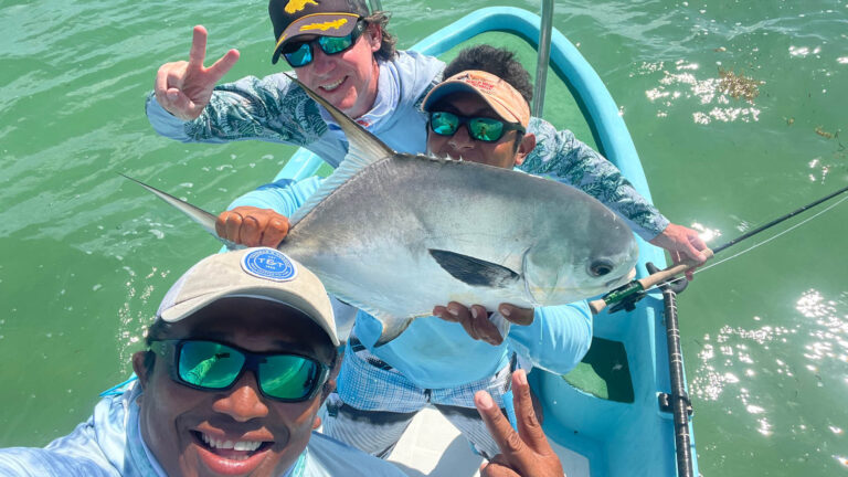 A fly fishermen catches a permit in Ascension Bay, Mexico.