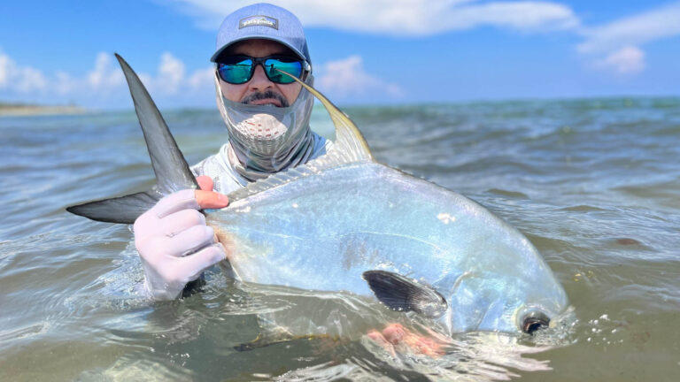 An inshore fly fishermen catches a permit in Ascension Bay, Mexico.