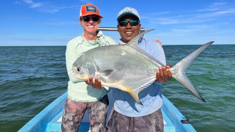 A fly fishermen catches a permit in Ascension Bay, Mexico.