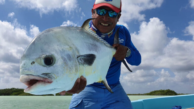 A fly fishermen catches a permit in Ascension Bay, Mexico.