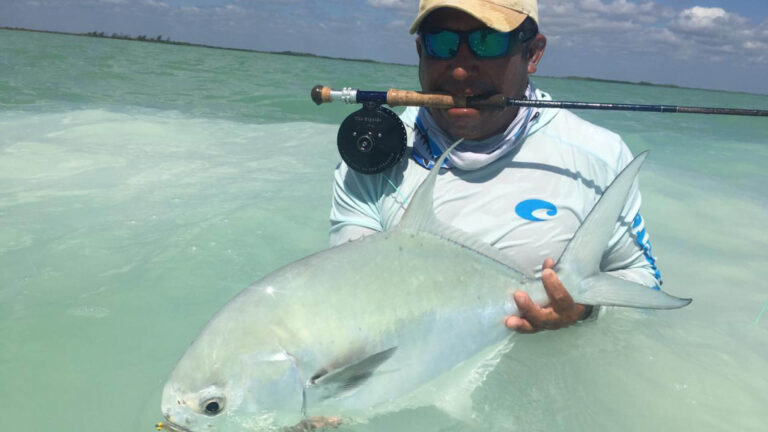 An inshore fly fishermen catches a permit in Ascension Bay, Mexico.